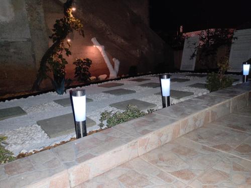 a row of lights on a stone pathway at night at LuMar Holidays and Apartments in Preko