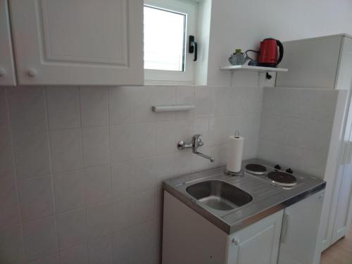 una pequeña cocina con fregadero y ventana en Apartments Tony - near the sea, en Stomorska