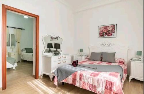 een witte slaapkamer met een bed en een spiegel bij Paraíso rural con piscina in El Garrobo