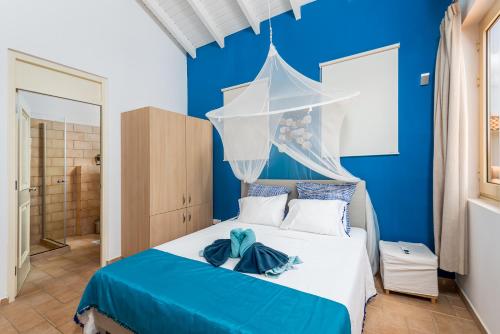 1 dormitorio azul con 1 cama con pared azul en living near the beach, en Kralendijk