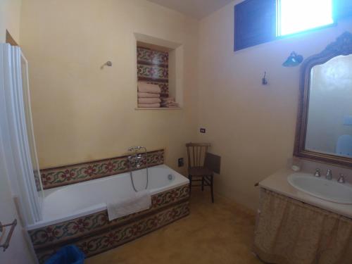 a bathroom with a bath tub and a sink at Masseria La Maestà - Dimora Storica in Sannicola