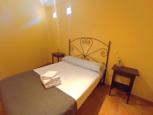 a small bedroom with a bed and a night stand at El Rincón del Sanabrés, cabeza mediana in Rascafría