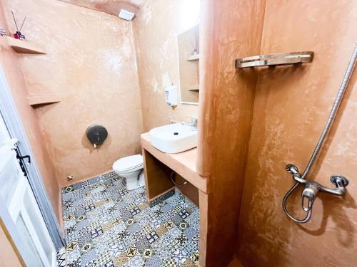 a small bathroom with a sink and a toilet at Riad Verus in Fès