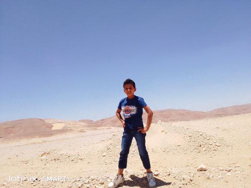 a young boy standing in the desert at رحله تسوق الغردقه in Hurghada