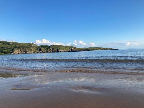 a beach with a body of water with waves at Millfarm House in Killybegs