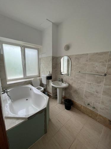 ein Badezimmer mit Badewanne, Toilette und Waschbecken in der Unterkunft Casa Lorena in Sărata-Monteoru