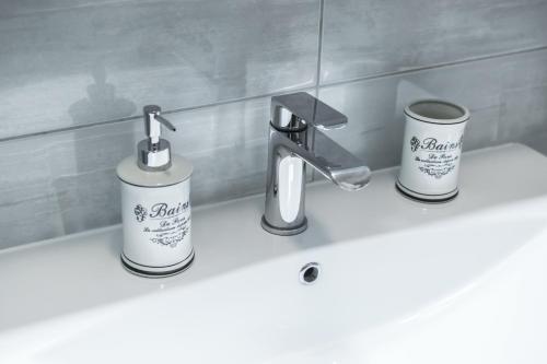 a bathroom sink with two cups and a faucet at Villa Magdalena, Biograd na Moru in Biograd na Moru