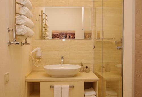 a bathroom with a sink and a glass shower at Design Hotel Skopeli in Odesa