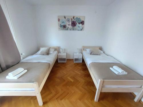 two beds in a room with wooden floors at Dream in Otočac