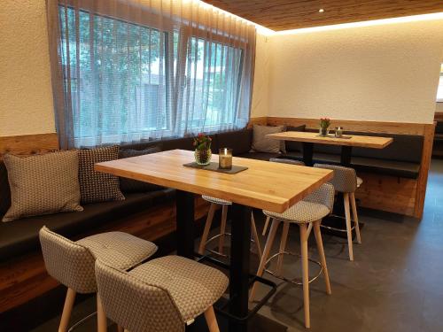 um restaurante com uma mesa e cadeiras de madeira em Haus Vilgrassa em Sankt Gallenkirch