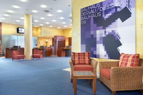 a lobby of a hospital with chairs and a table at Radisson Blu Fürst Leopold Hotel in Dessau
