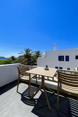 Una mesa de madera y dos sillas en un balcón. en Nautilus Serifos, en Livadakia