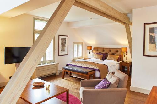 um quarto com uma cama e uma sala de estar em Das Elbcottage - Remise am Süllberg - Boarding House em Hamburgo