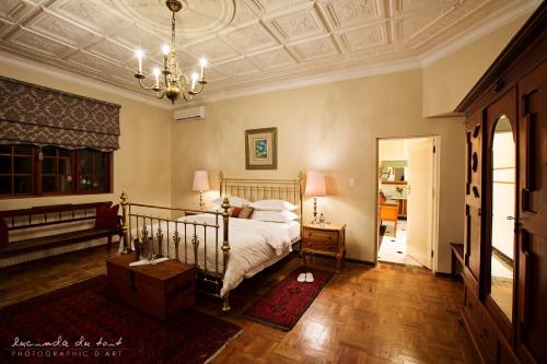 a bedroom with a bed and a chandelier at Kleinkaap Boutique Hotel in Centurion