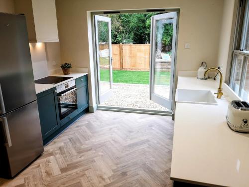 a kitchen with a door leading to a yard at Stunning New Forest Cottage close to Paultons Park in Ower