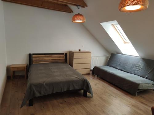 een slaapkamer met een bed en een bank bij Attic Apartment in Piešťany