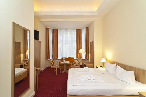 فندق فيفالدي برلين آم كورفورشتيندام في برلين: غرفة الفندق بسرير وطاولة