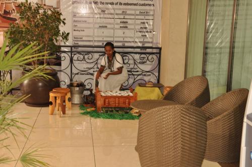 a woman sitting in a room with two chairs at Ambassador Hotel in Addis Ababa
