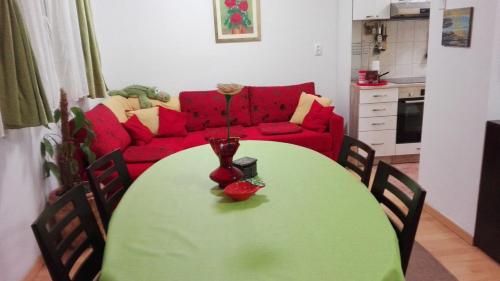a green table in a living room with a red couch at STUDIO APARTMAN Marita in Split