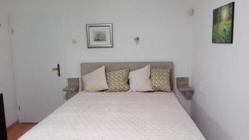 a bedroom with a bed with white sheets and pillows at STUDIO APARTMAN Marita in Split