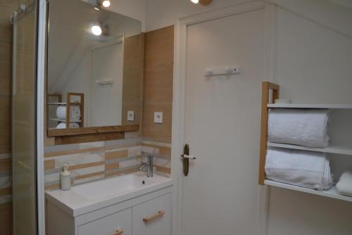 y baño con lavabo y espejo. en DNJ Appart Hotel, en Meung-sur-Loire
