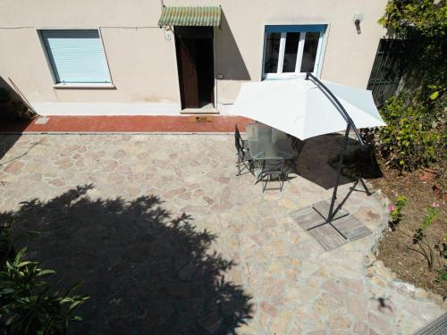 a patio with a table and chairs in front of a house at Il giardino delle Cycas in Il Romito