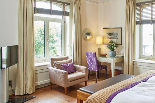 a hotel room with a bed and a desk and chairs at Das Elbcottage - Remise am Süllberg - Boarding House in Hamburg