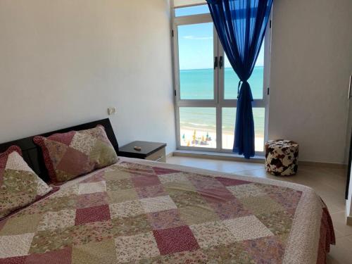 a bedroom with a bed with a view of the beach at Isabel in Durrës