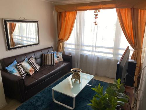 sala de estar con sofá de cuero y mesa de centro en departamento Amoblado Paola 1 en Calama