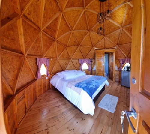 1 dormitorio con 1 cama grande en una yurta en Domos Lago Muisca Chia en Aquitania