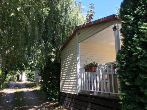 a house with a porch with a potted plant on it at Mobile home avec parking in Chorges