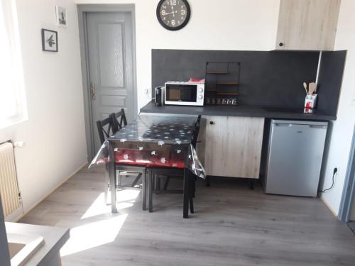 une petite cuisine avec une table et un micro-ondes dans l'établissement Gambetta Insolite, à Chambéry