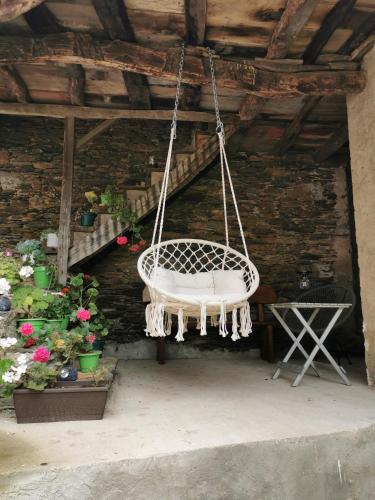 a white swing hanging from a ceiling with flowers at La casona El Espín in Serandinas