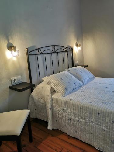 1 dormitorio con cama, silla y luces en La casona El Espín, en Serandinas