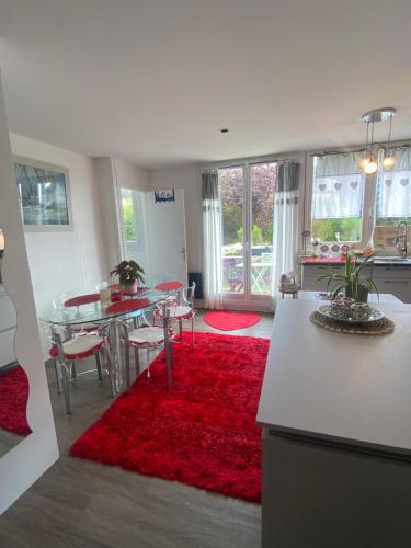 una cucina con tavolo e tappeto rosso di Appartement Veules roses , la cressonnière: « Veules & Victor «  a Veules-les-Roses