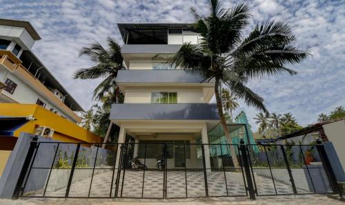 a building with a palm tree in front of it at Itsy By Treebo - Ushodaya Royal Residency in Trivandrum