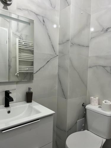 a white bathroom with a toilet and a sink at Apartament Alexandra Ressidence in Oradea