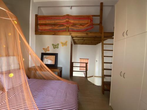 ein Schlafzimmer mit einem Etagenbett und einer Leiter in der Unterkunft Rafaella's Maisonette at Rafaella Resort in Kokóni