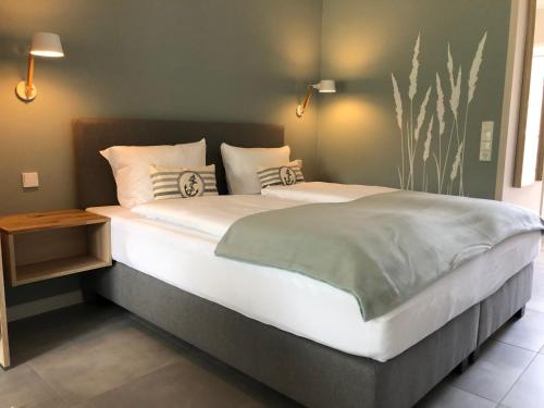 a bedroom with a large bed with white sheets and pillows at Gästehaus Muhl in Strukkamp auf Fehmarn