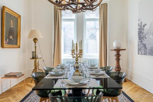 une salle à manger avec une table, des chaises et un lustre dans l'établissement LUXUEUX APPARTEMENT CENTRE VILLE, à Strasbourg