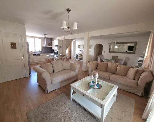 uma sala de estar com dois sofás e uma mesa em Maison individuelle avec sa piscine privée em Clermont-Ferrand