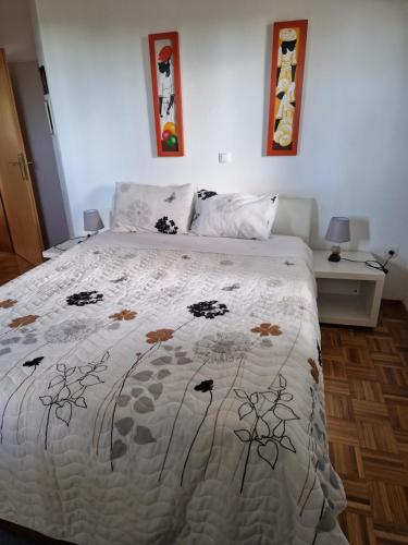 ein Schlafzimmer mit einem Bett mit einer Bettdecke darauf in der Unterkunft Garden apartment in Sečovlje