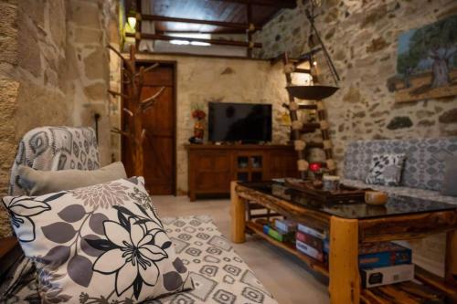 a living room with a couch and a tv at Dioni Stone House in Petrokefalo