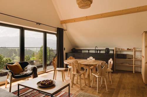 sala de estar con mesa de madera y sillas en Osada Matygówka, en Gliczarów Górny