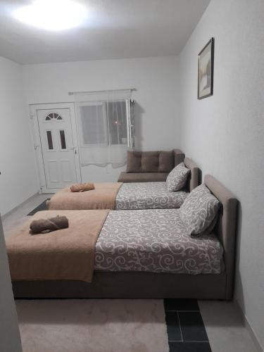 a bedroom with two beds and a couch at Apartmani Pejovic in Mojkovac