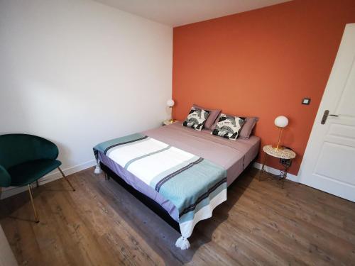 a bedroom with a bed with an orange wall at Jacuzzi Terrasse 86 - Terrasse & Climatisation - 4 personnes - BnB Epernay in Épernay