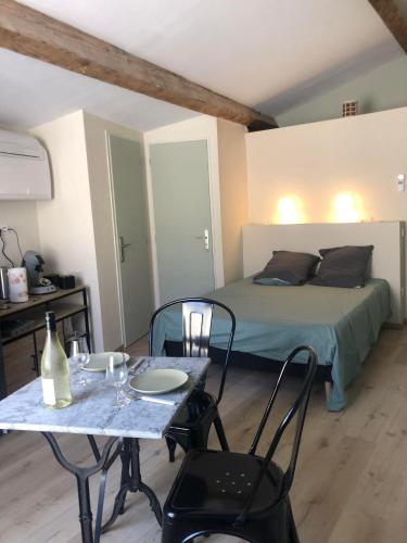 une chambre avec un lit, une table et des chaises dans l'établissement ARLES: Studio de la place, à Arles