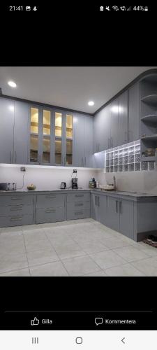 a large kitchen with white cabinets and white tile floors at Matteo's hus VILLA RENTAL in Zamboanguita