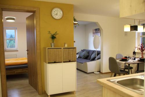 cocina y sala de estar con sofá y reloj en Ferienhaus Kühlwein, en Bad Goisern