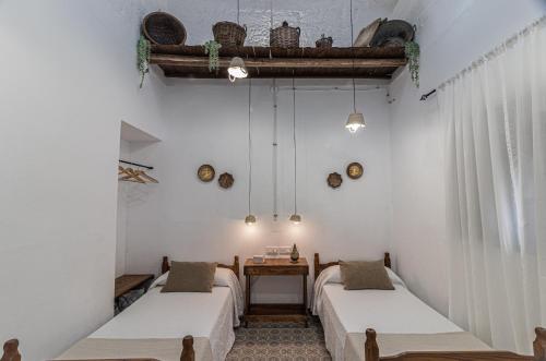 2 camas en una habitación con paredes blancas en La Vaquería en Niebla